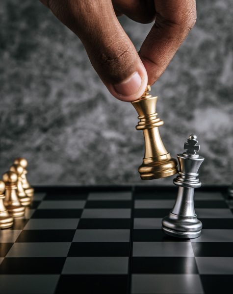 Hand of man playing chess for business planning and comparison of metaphor, selective focus
