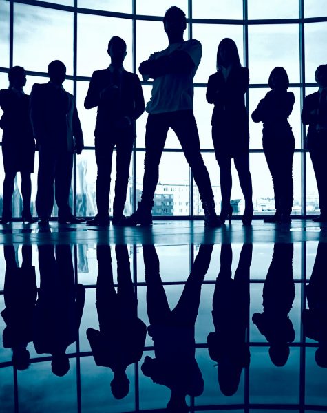 Business team standing against window with leader in front